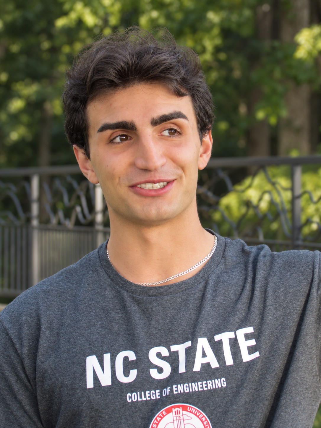 Roman outdoors, wearing a gray NC State engineering shirt.